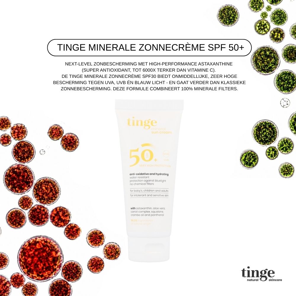 Drie Tinge zonnecrème tubes met tas op zand.