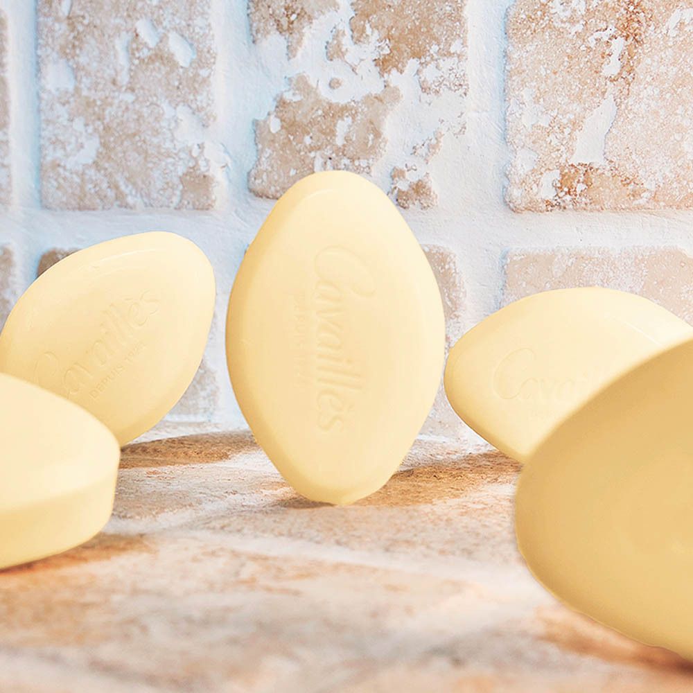 Plusieurs savons ovales jaunâtres sur une surface.