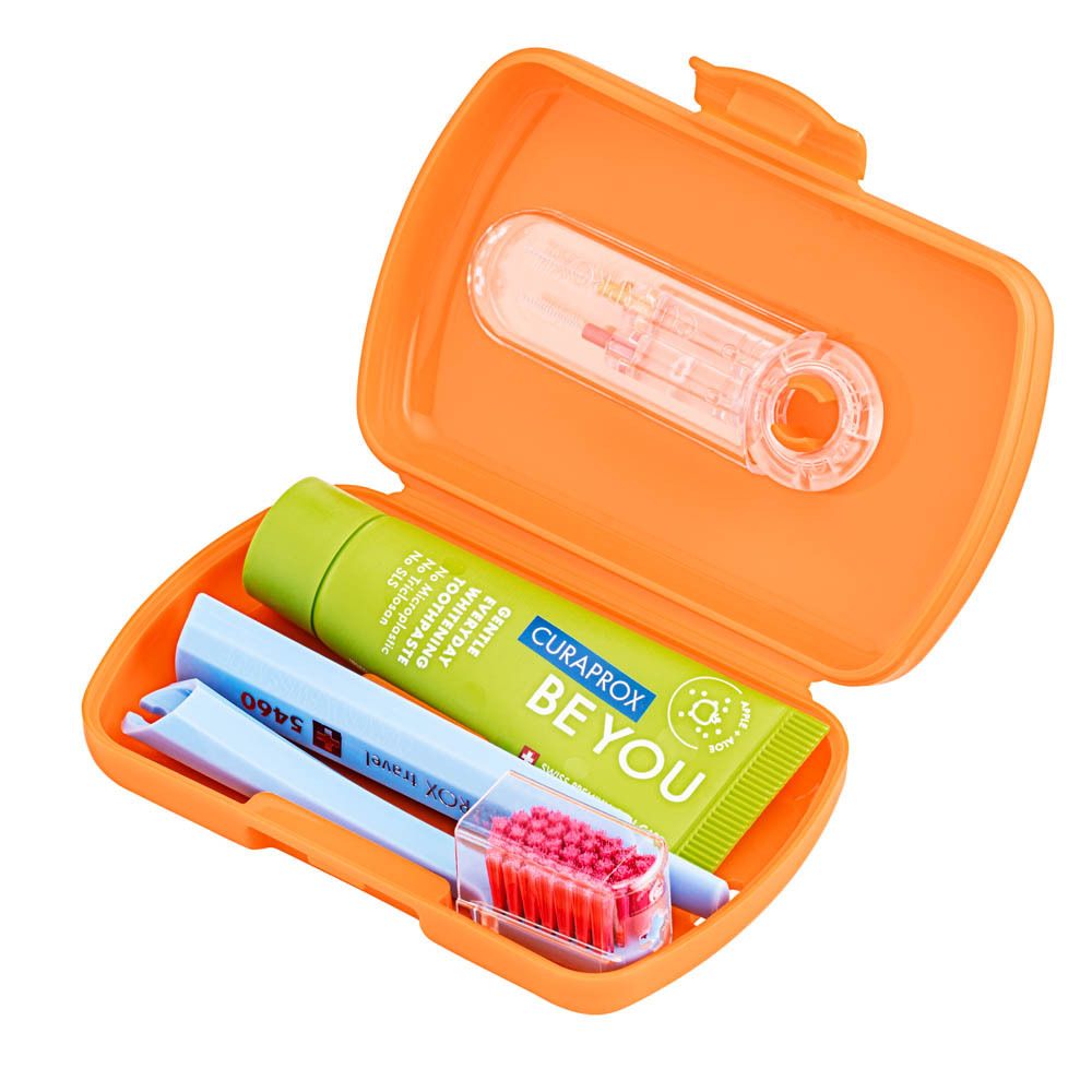 Étui de voyage orange avec brosse à dents, dentifrice et fil dentaire CURAPROX.