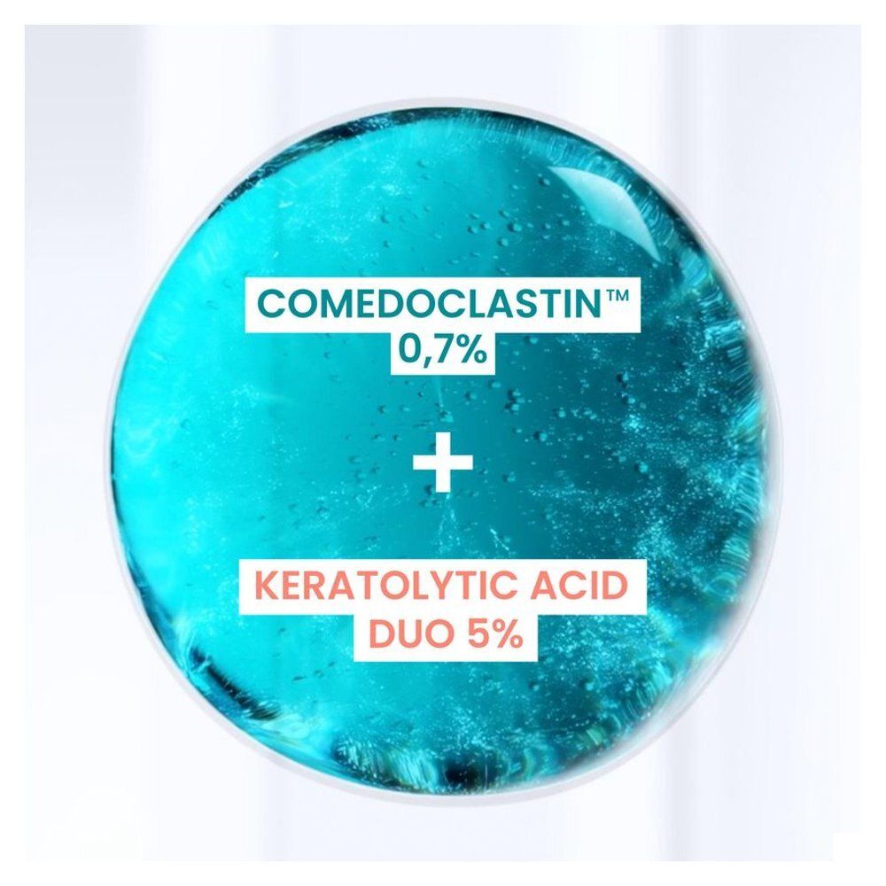 Gros plan d'un liquide bleu. Texte: Comedoclastin 0,7% + Duo d'acides kératolytiques 5%.