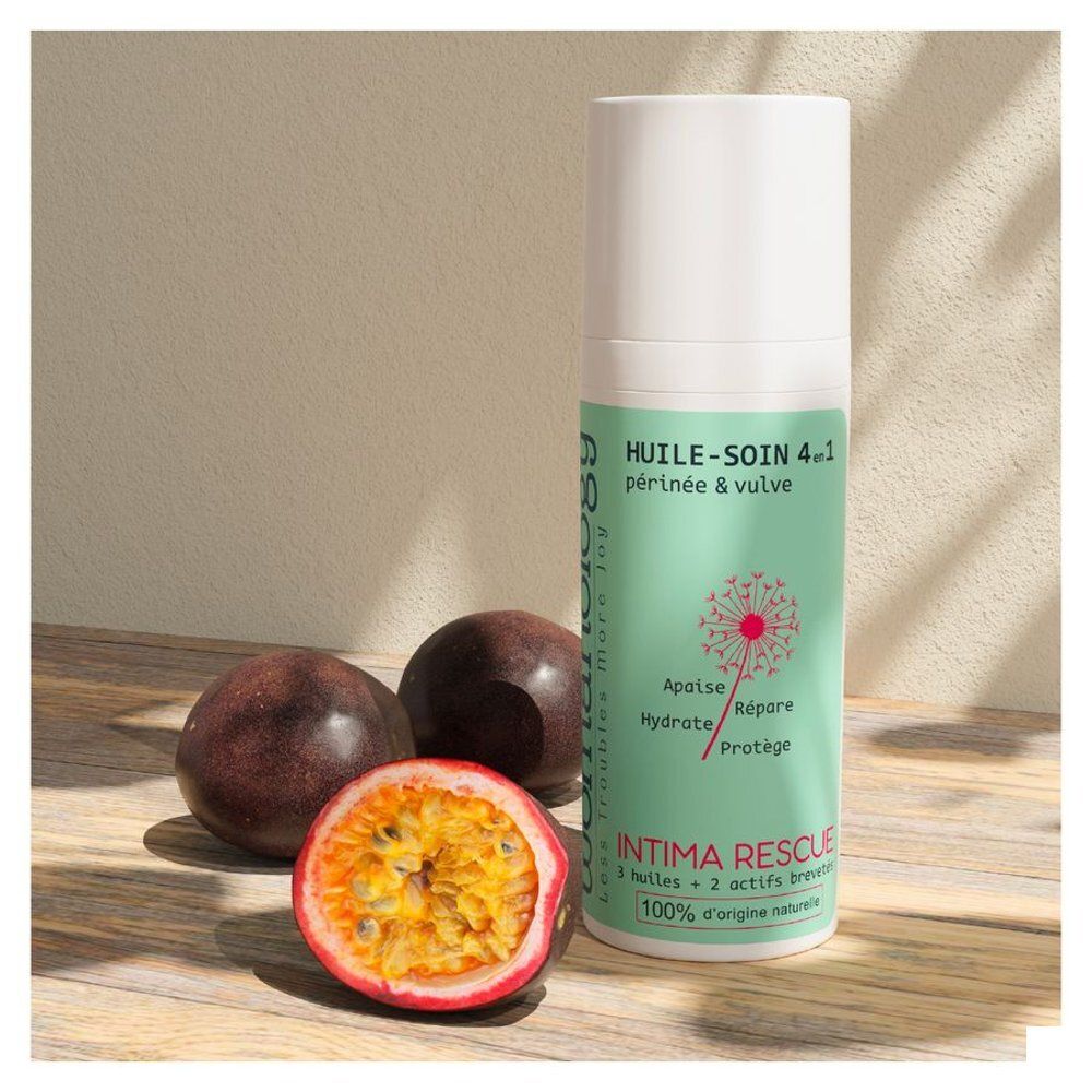 Womanology Intima Rescue fles, naast passievruchten. Product met tekst: Huile-Soin 4-en-1, Périnée & vulva. 100% natuurlijk.