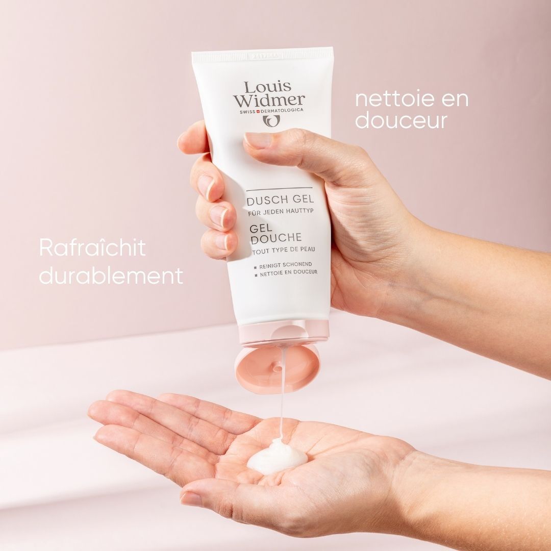 Main tenant un tube de gel douche Louis Widmer. Le gel coule. Texte: Dusch Gel, Gel Douche, Nettoie en douceur, Rafraîchit durablement.