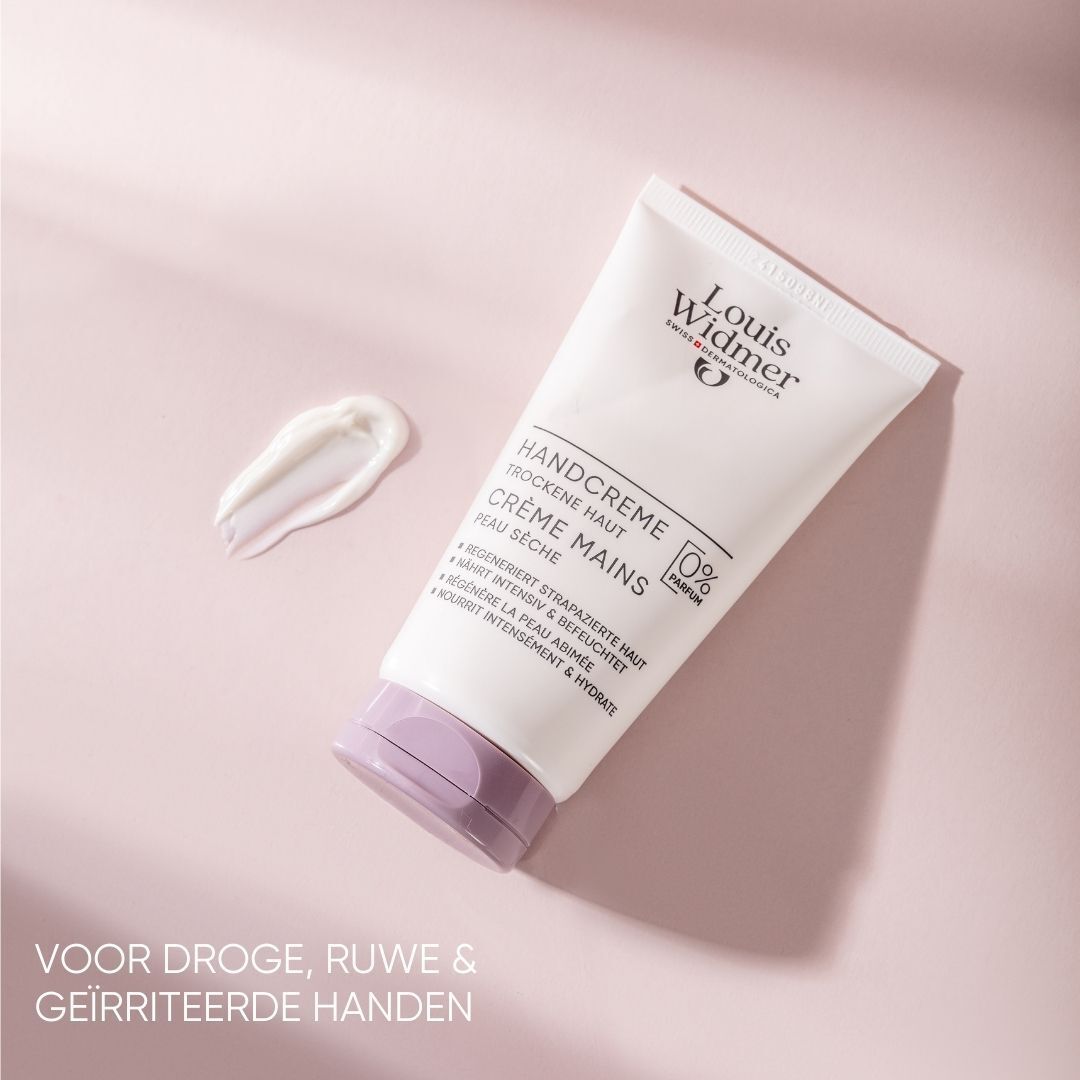 Handcrèmetube met een klodder crème ernaast. Opschrift: Louis Widmer, Handcreme, droge huid, 0% parfum. Paarse dop.