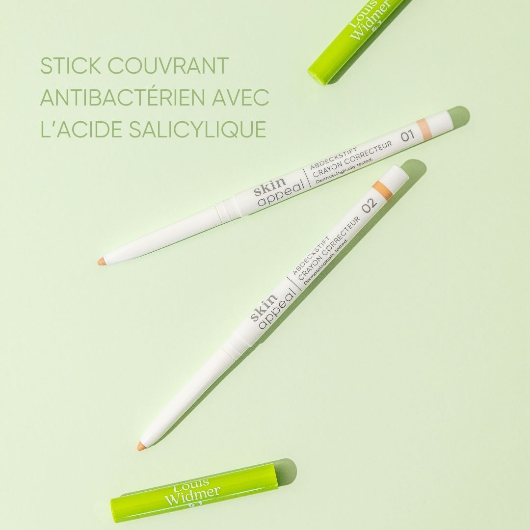 Trois crayons correcteurs Skin Appeal. Deux crayons debout, un couché. Inscription Skin Appeal et Crayon Correcteur. Fond vert.