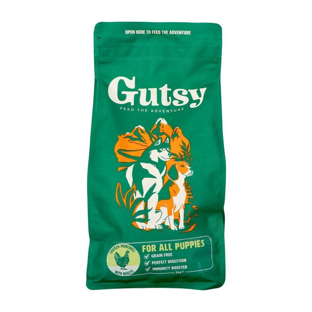 Emballage vert avec le mot Gutsy. Illustration de deux chiens et texte: FOR ALL PUPPIES. Contient également le texte: Grain Free, Perfect Digestion.