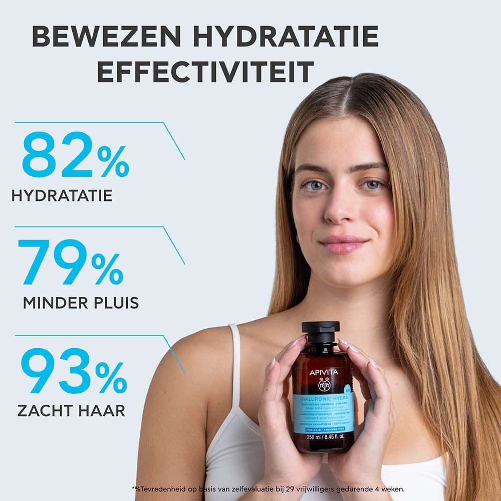 Promotionele afbeelding: Vrouw met lang haar houdt Apivita Hyaluronic Hydra Shampoo vast. Resultaten: 82% hydratatie, 79% minder pluis, 93% zacht haar.