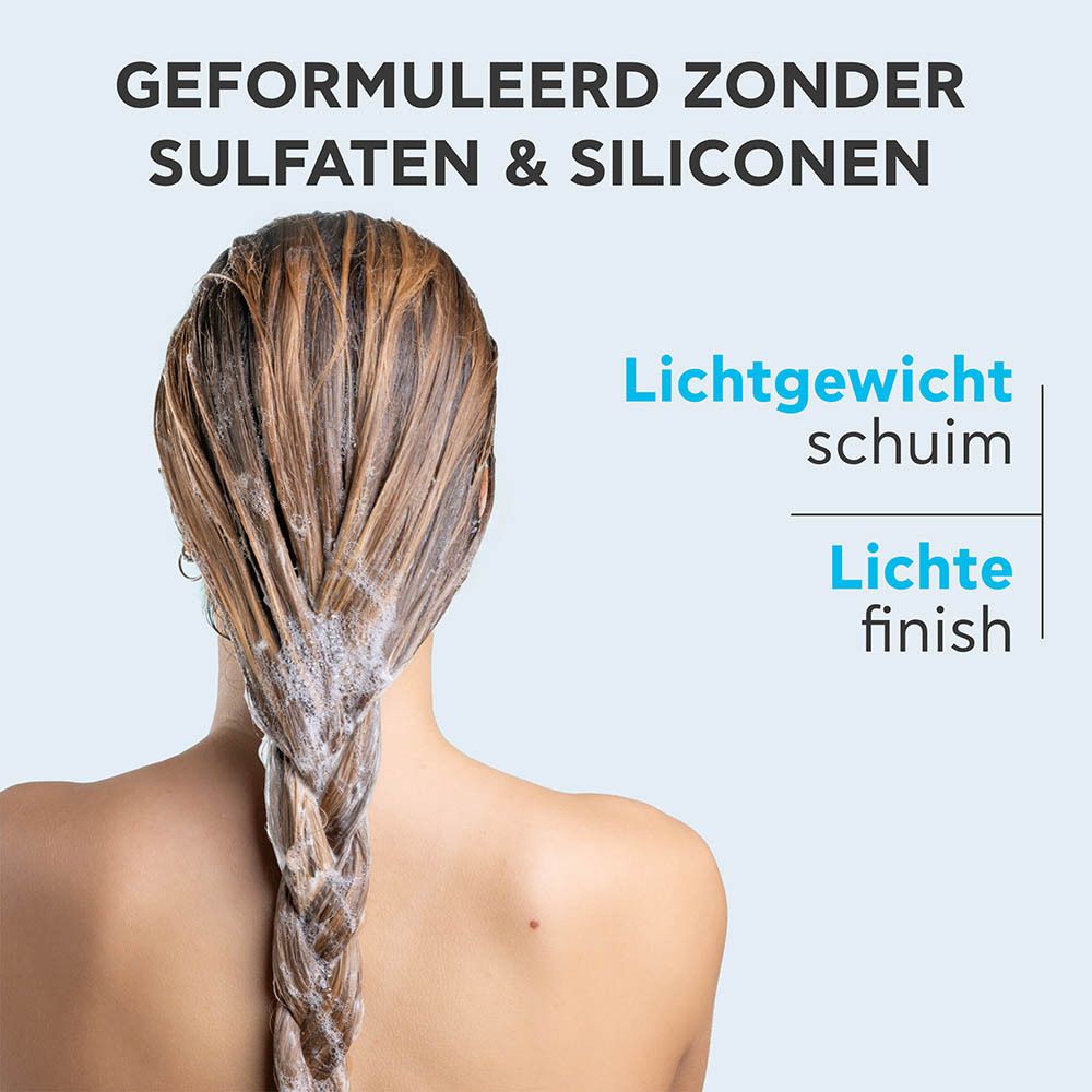 Promotionele afbeelding: Achteraanzicht van een vrouw met gevlochten, schuimend haar. Apivita Hyaluronic Hydra Shampoo is vrij van sulfaten en siliconen.