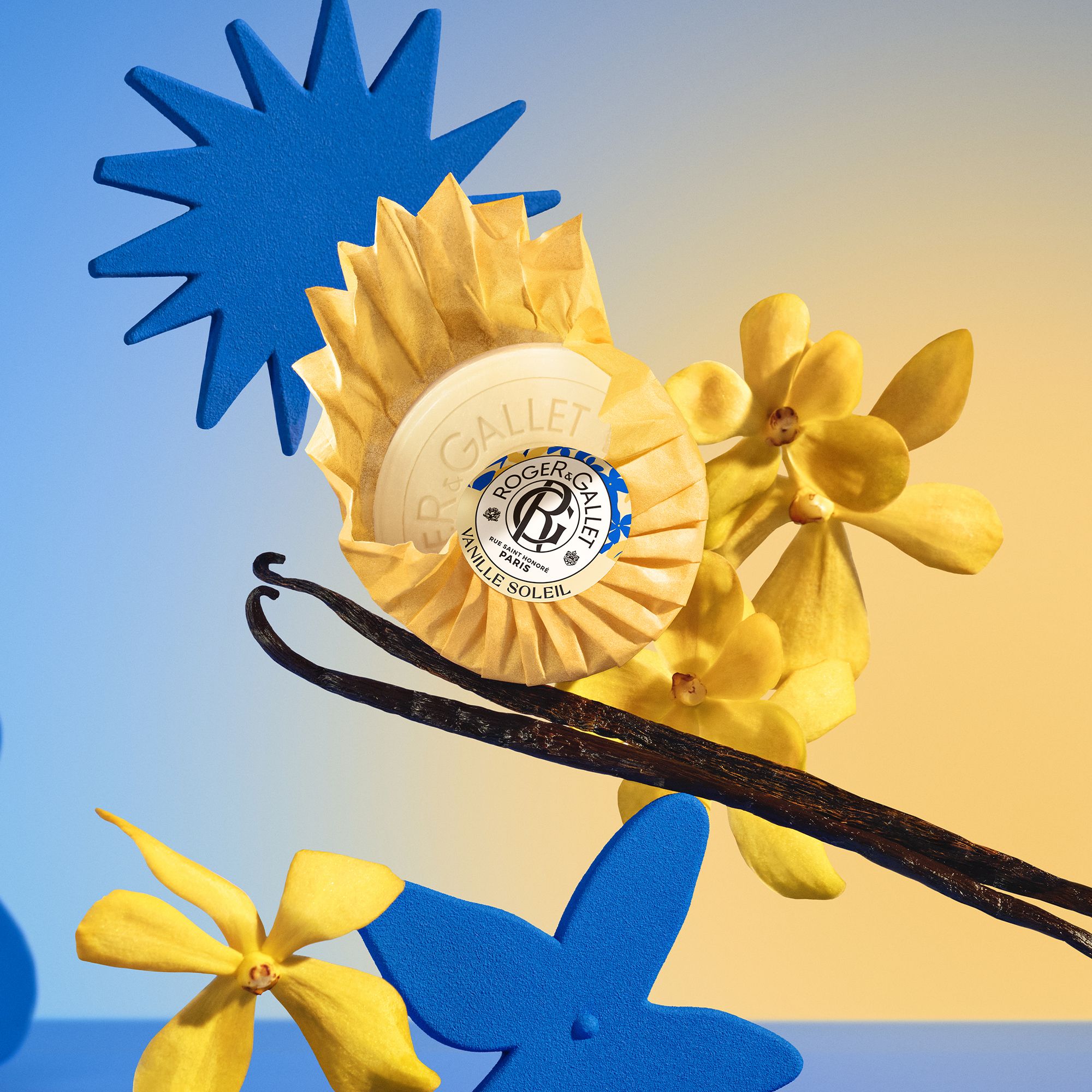 Zeep met gele papieren verpakking, vanille, bloemen en sterren. Opschrift: Roger & Gallet.