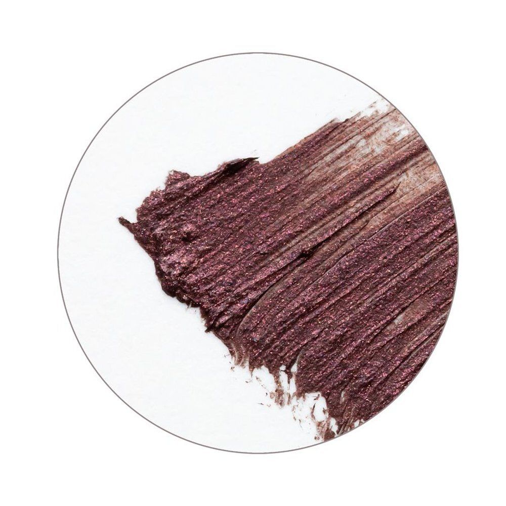 Échantillon de mascara brun-rouge circulaire sur fond blanc. Texture visible.
