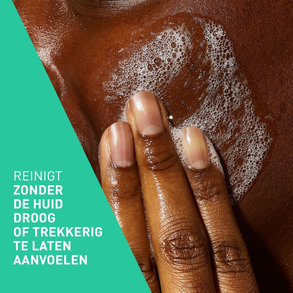 Close-up van een persoon die schuim op de huid aanbrengt. Tekst: Reinigt zonder de huid droog of trekkerig te laten aanvoelen.