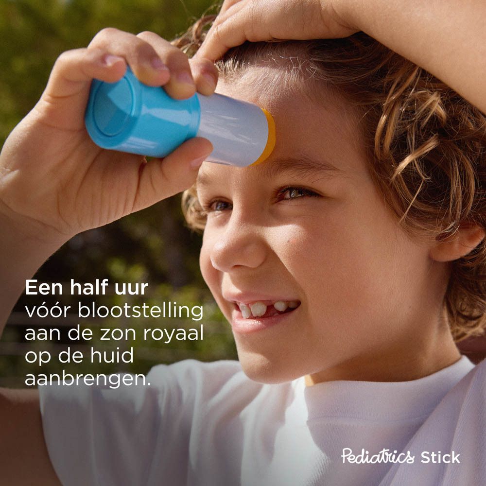 Kind brengt zonnebrandstick aan op voorhoofd. Tekst: Royaal aanbrengen, een half uur voor blootstelling aan de zon.
