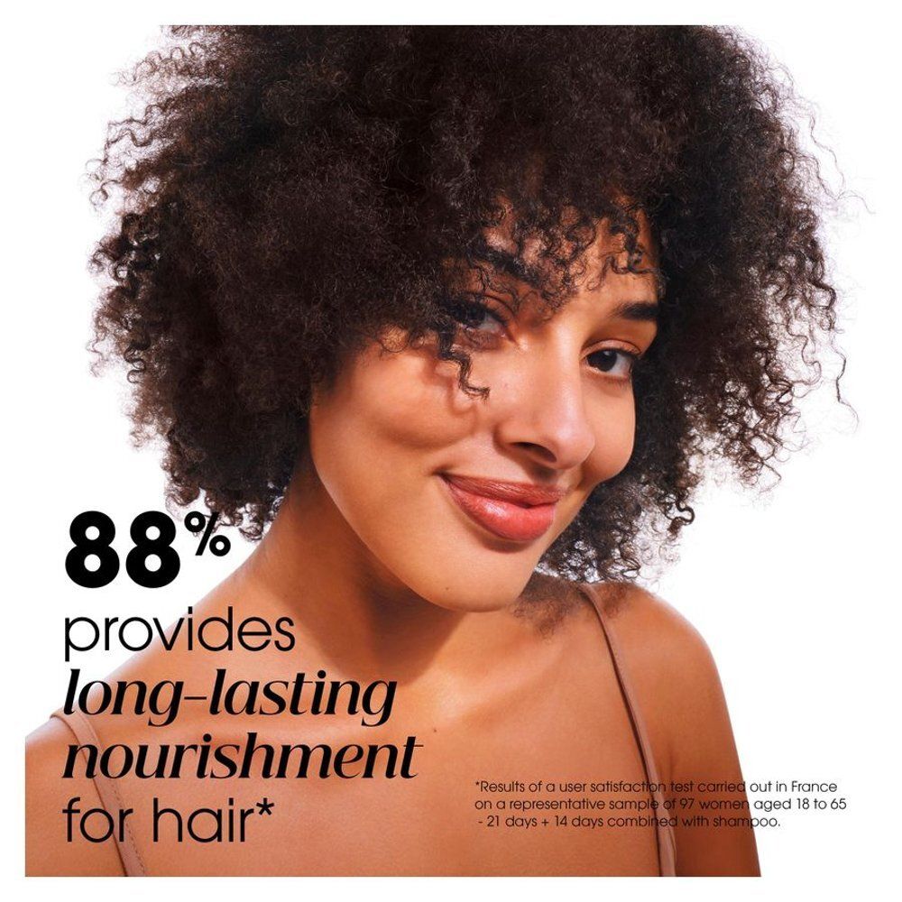 Vrouw met krullend haar. Tekst: 88% biedt langdurige voeding voor het haar.