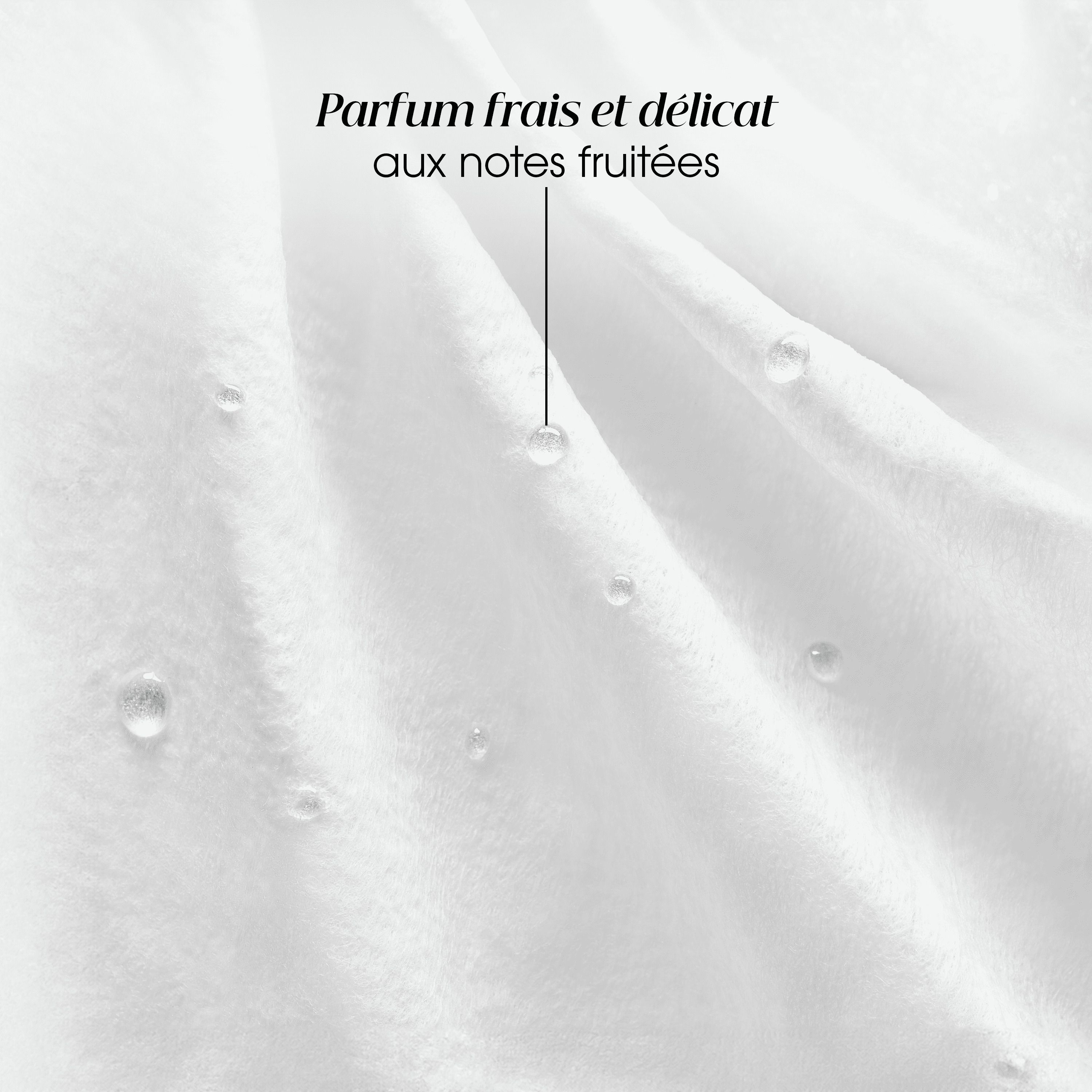 Gros plan sur un tissu blanc avec des gouttes d'eau. Texte: Parfum frais et délicat aux notes fruitées.