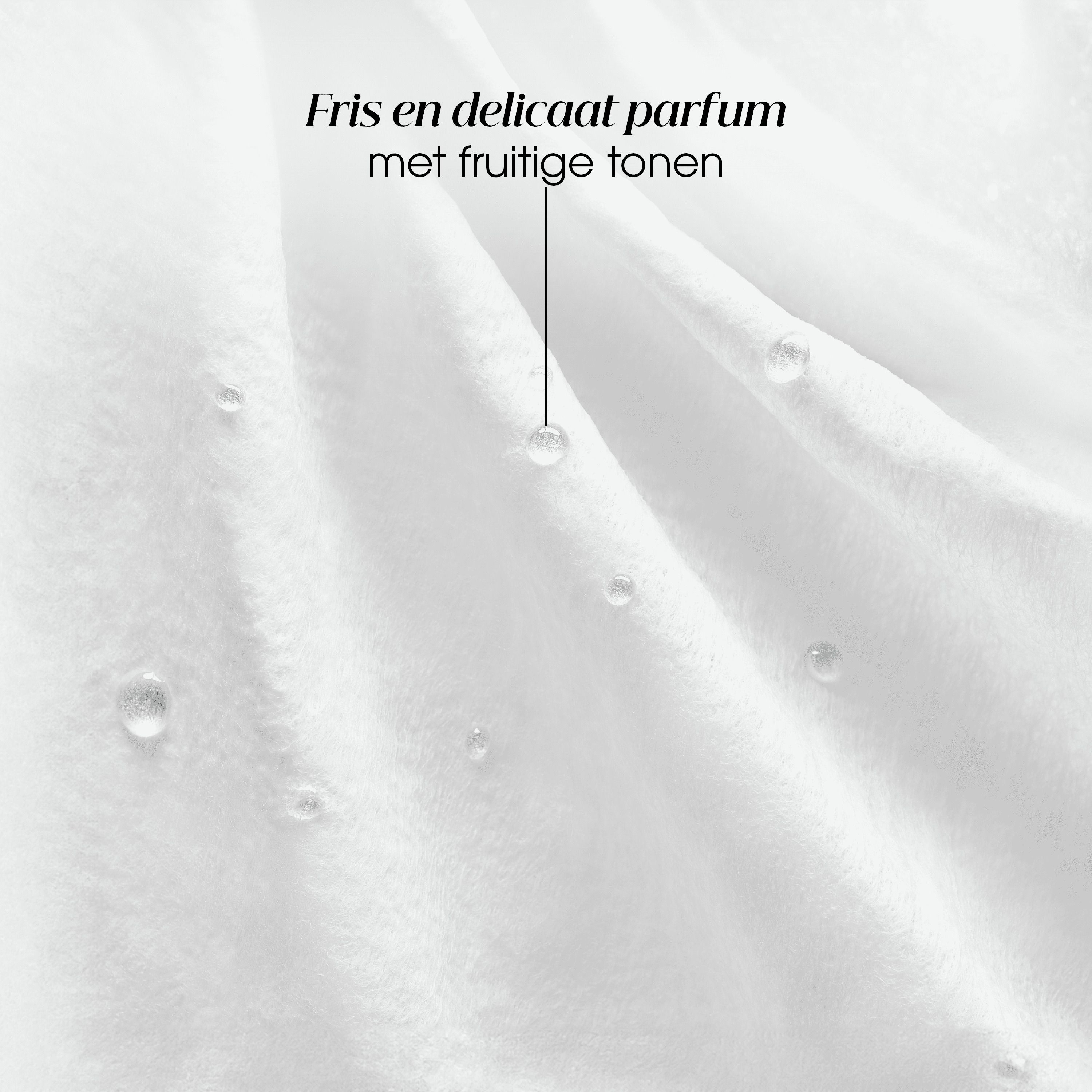 Close-up van witte stof met waterdruppels. Tekst: Fris en delicaat parfum met fruitige tonen.
