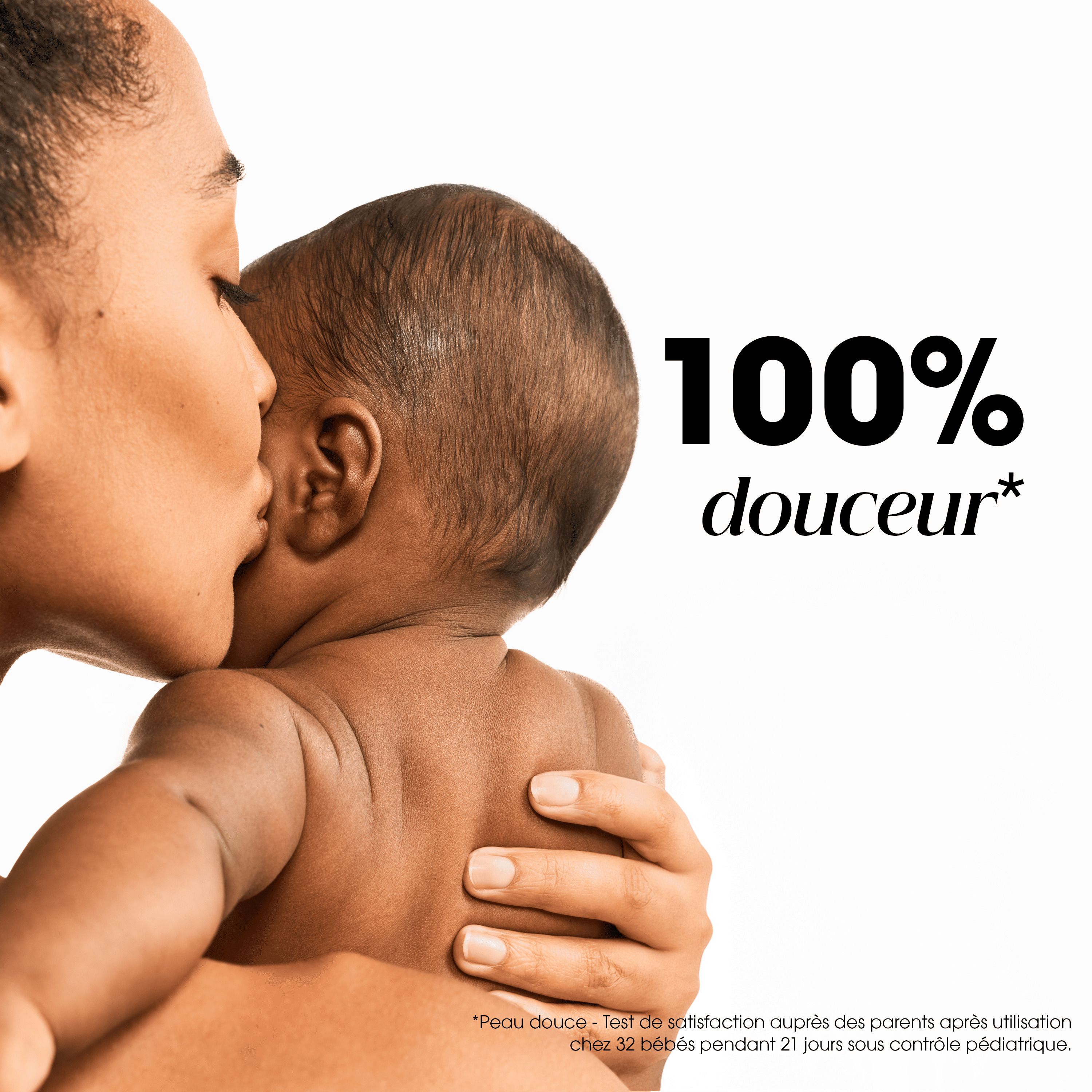 Mère embrassant un bébé sur la joue. Texte: 100% douceur.