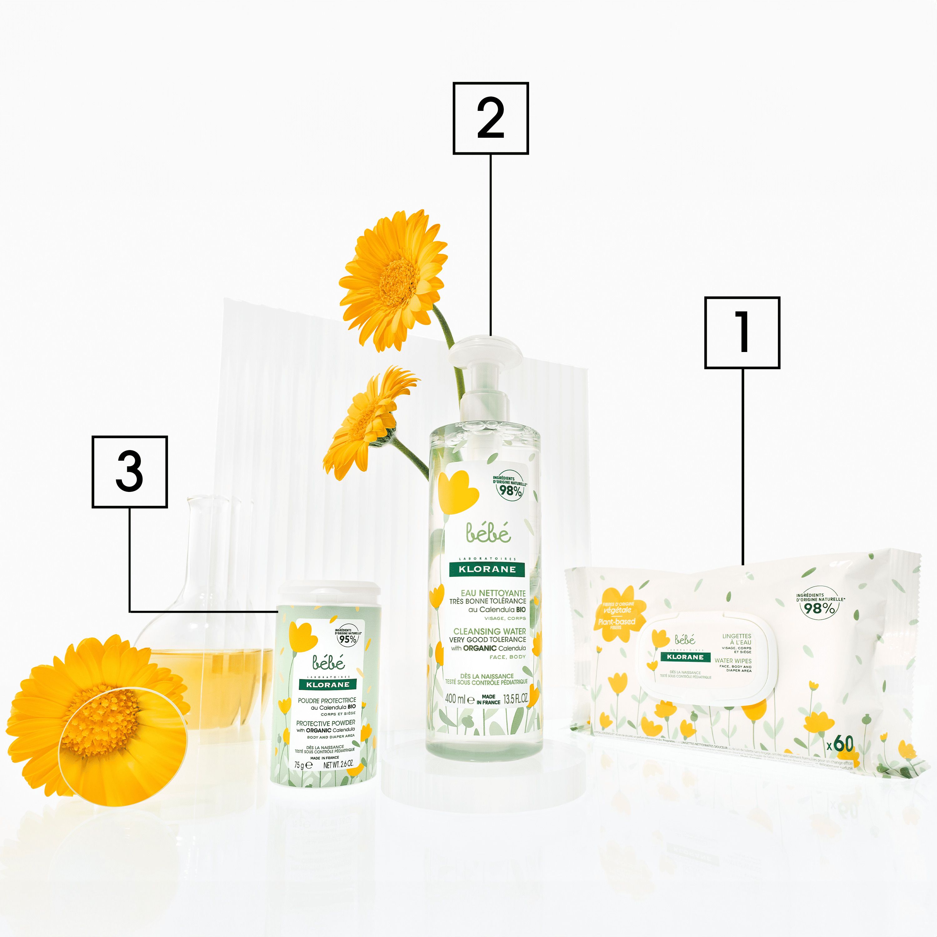 Trois produits Klorane Bébé: lingettes, base lavante et crème. Fleurs jaunes.