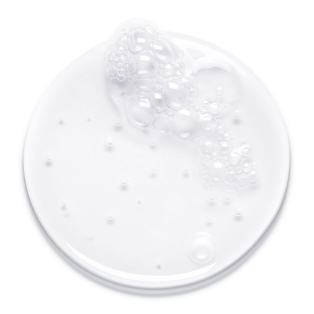 Wit bord met schuim. Opschrift: Bioderma, Hydrabio Gel Moussant. Product in gebruik.