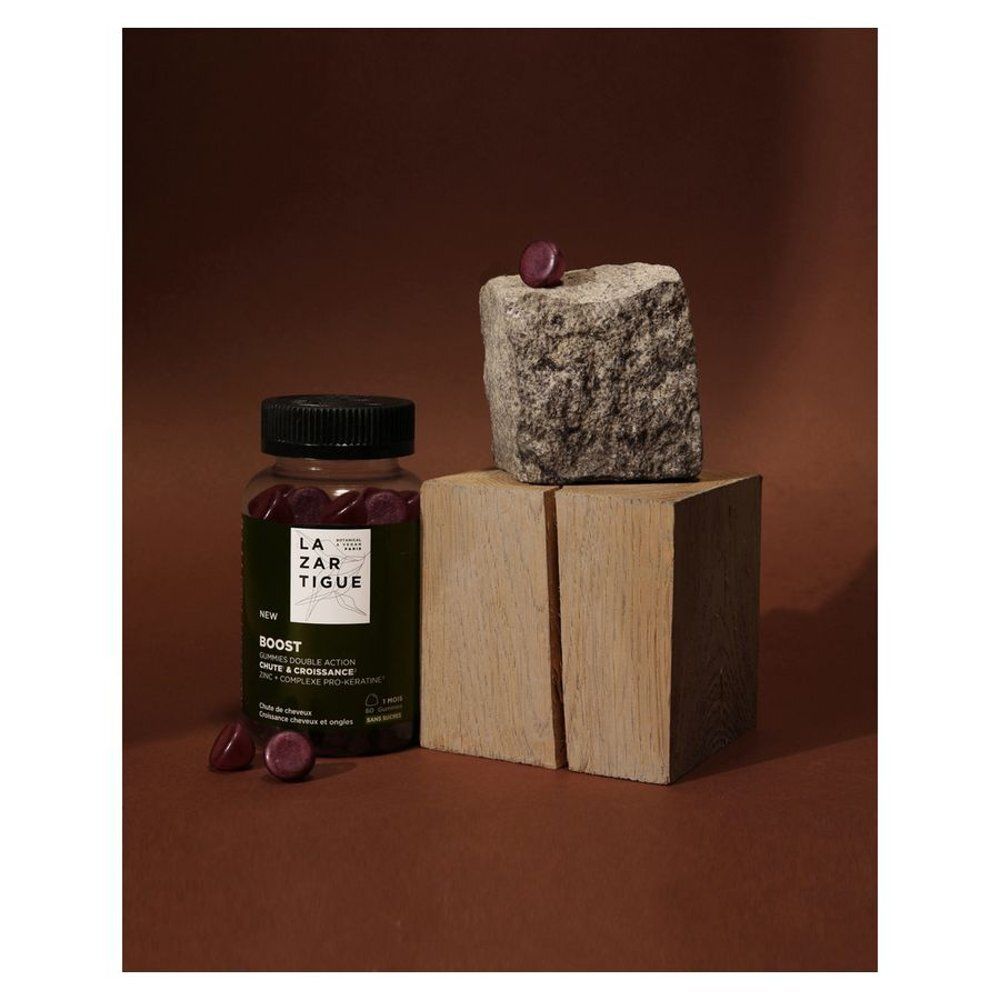 Flacon et gommes sur blocs de bois et de pierre. Inscription: LAZARTIGUE, BOOST.