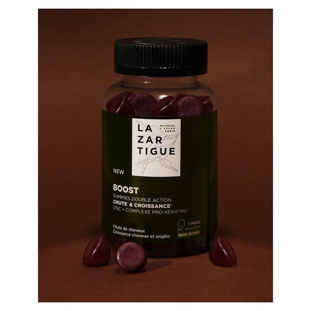 Fles en gummies op bruine achtergrond. Opschrift: LAZARTIGUE, BOOST, Haaruitval & Groei.