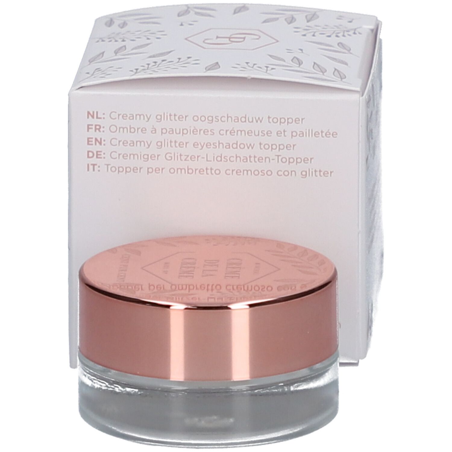 Topper crémeux pour les yeux pailleté dans un pot en verre avec couvercle doré rose. À côté, une boîte avec du texte.