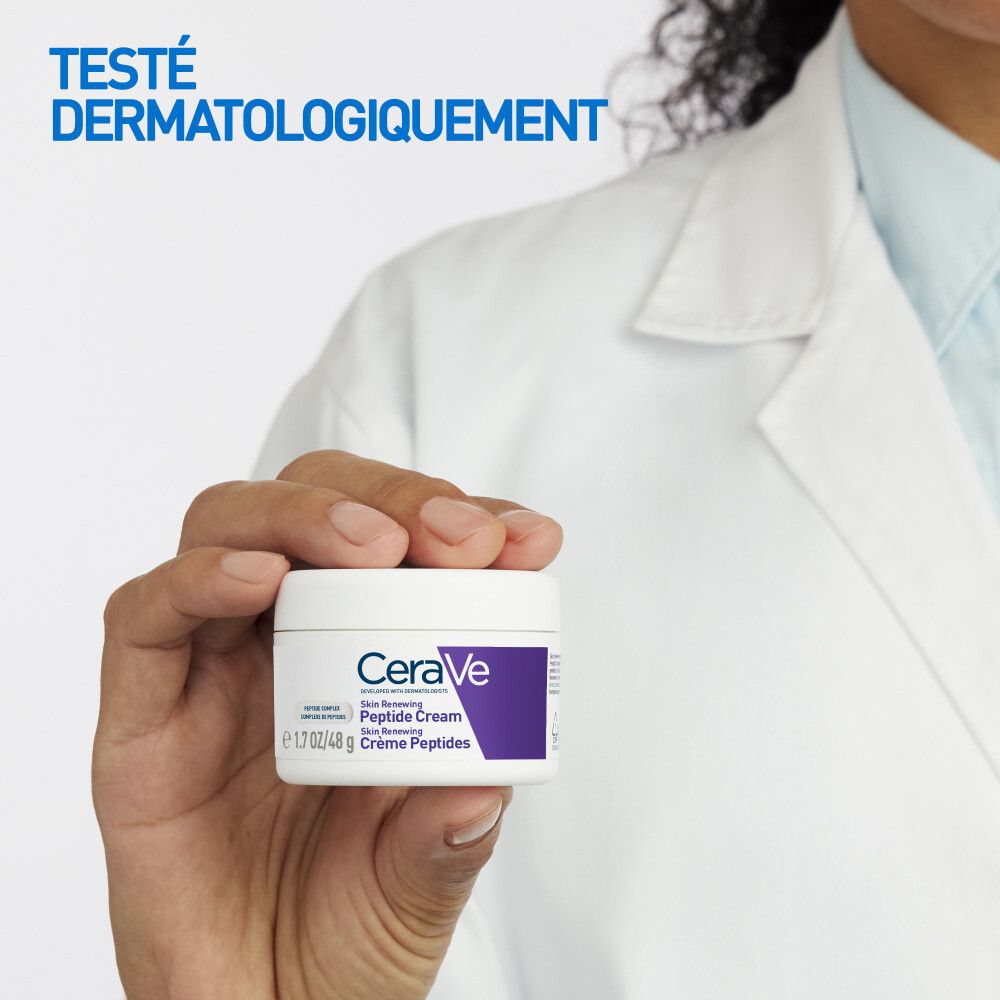 Main tenant un pot de crème. Texte: CeraVe Skin Renewing Peptide Cream. Testé dermatologiquement.