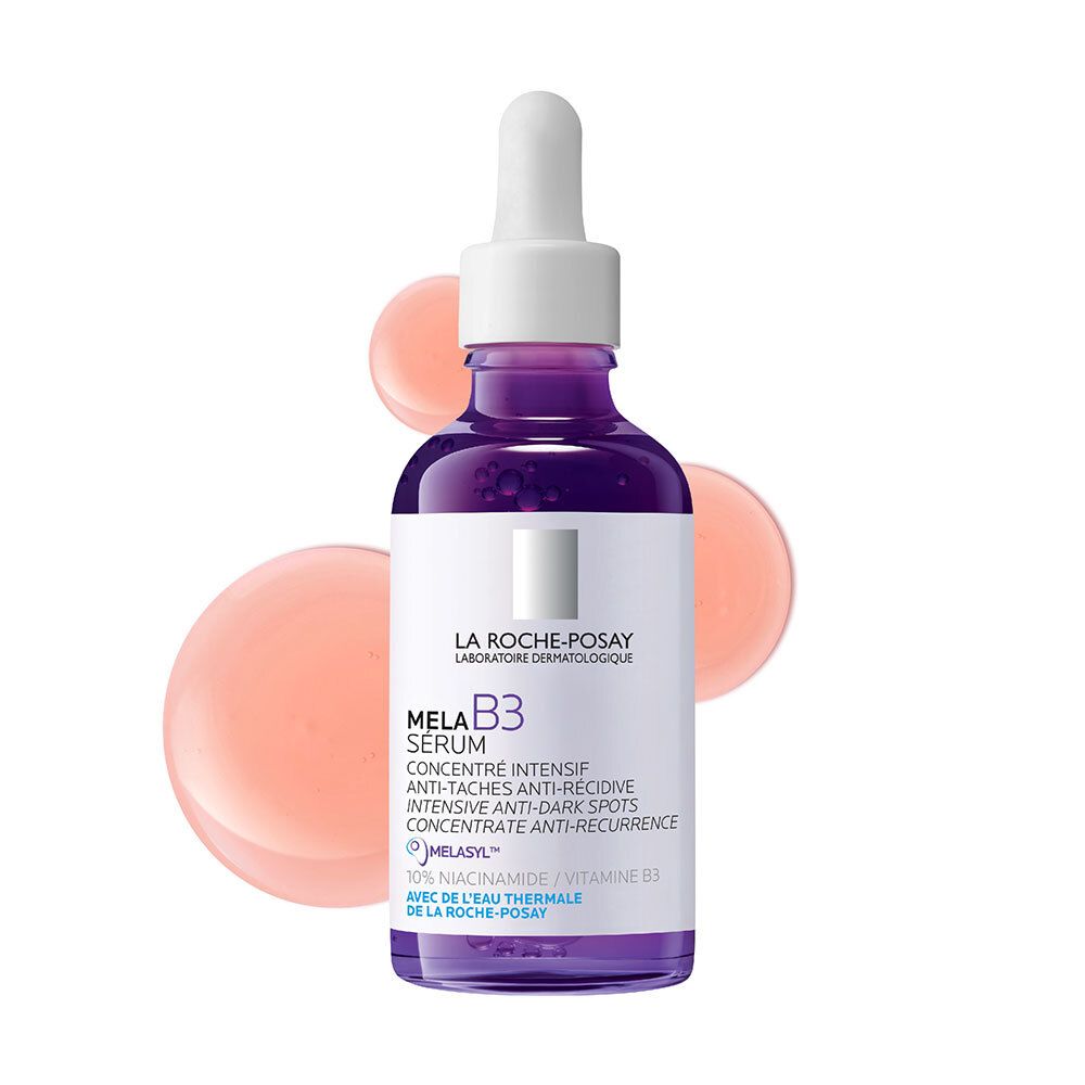 Mela B3 Serum La Roche-Posay. Paarse fles met pipet. Roze druppels op de achtergrond.