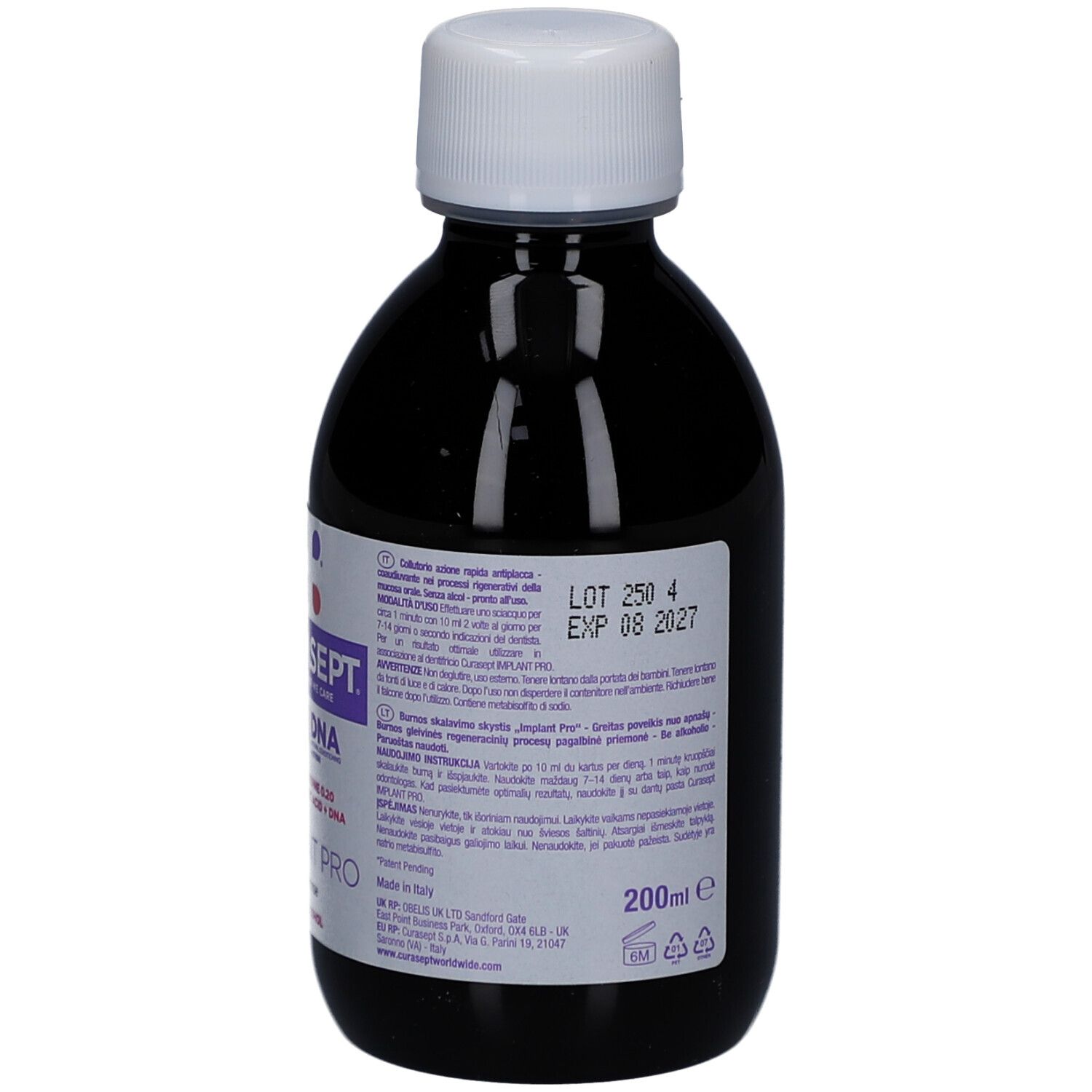 Achterkant van een fles met donkere vloeistof en witte dop. Etiket met tekst en lotnummer.