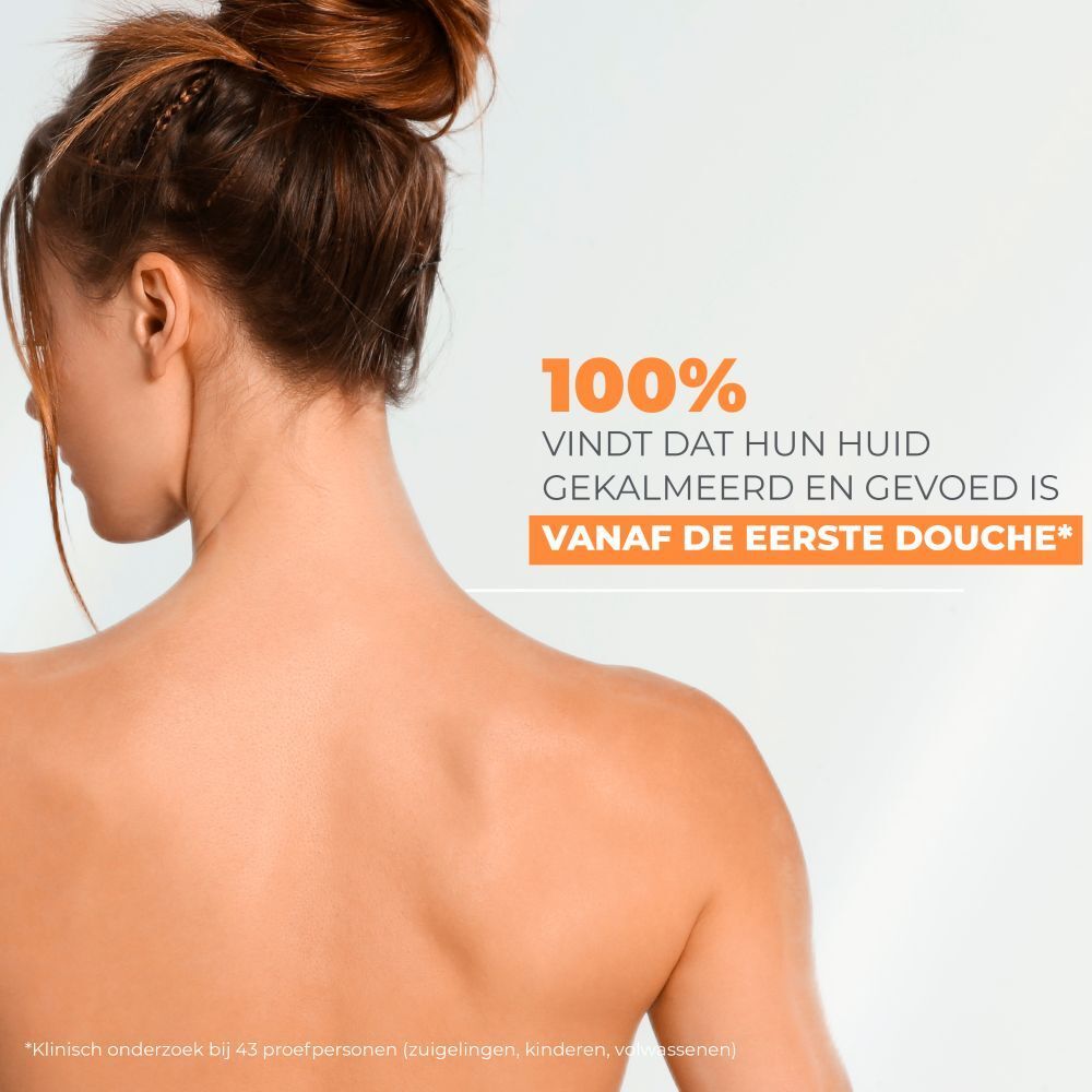 Rug van een vrouw. Opschrift: 100% vindt dat hun huid gekalmeerd en gevoed is vanaf de eerste douche.