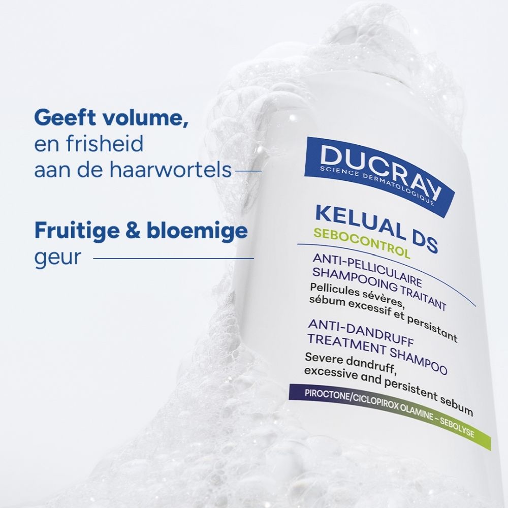Een fles Ducray Kelual DS shampoo met schuim, met tekst over voordelen ernaast.