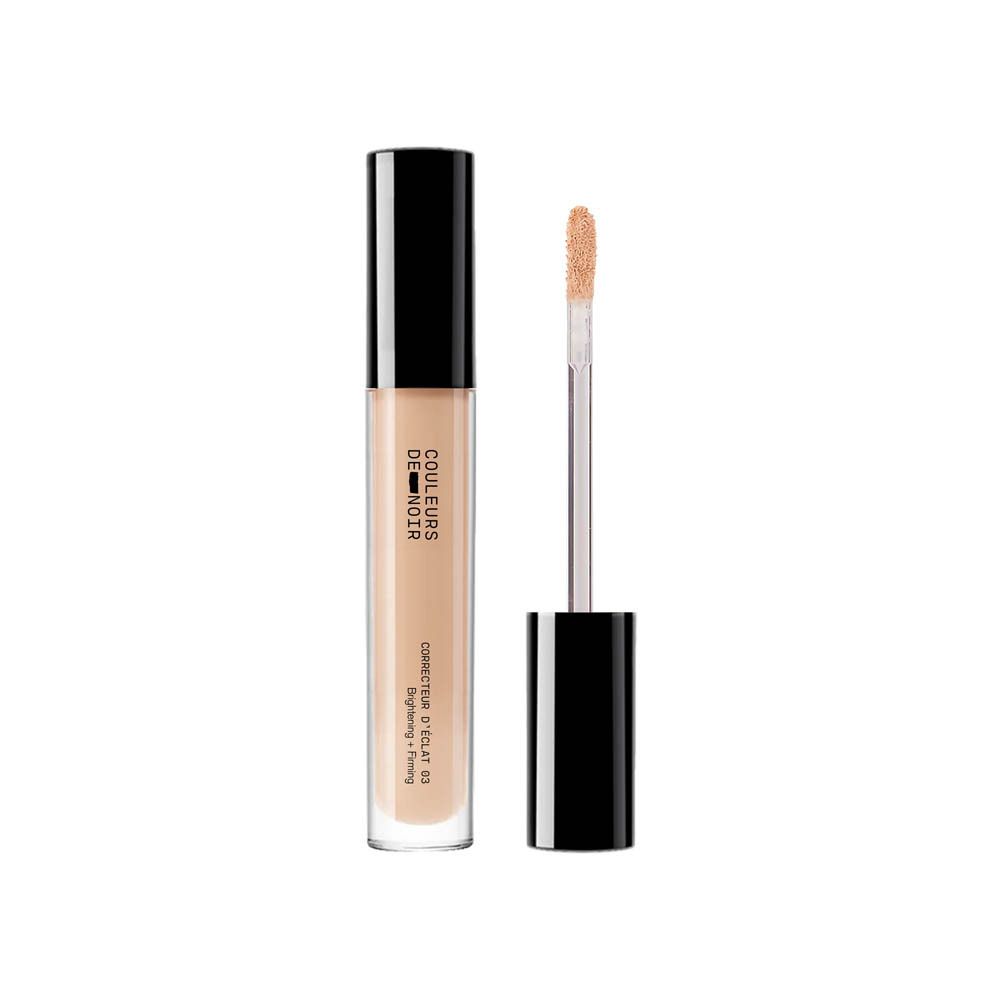 Beige concealer tube met zwarte dop en applicator. Opschrift: COULEURS DE NOIR, Correcteur d’éclat 03 Moyen. Verheldert en verstevigt.