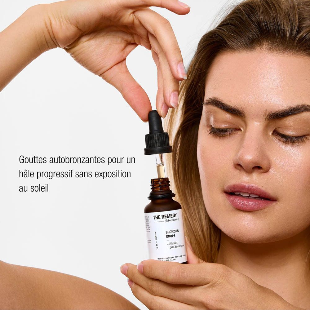 Femme tenant un flacon brun avec pipette. Le nom du produit et les ingrédients sont visibles.