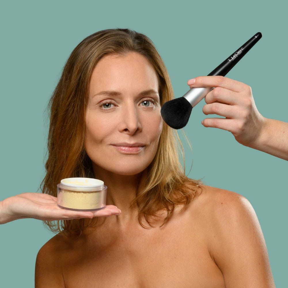 Femme avec poudre et pinceau. Nom du produit: Poudre de Riz Dermophile de T. LeClerc. Poudre en pot.