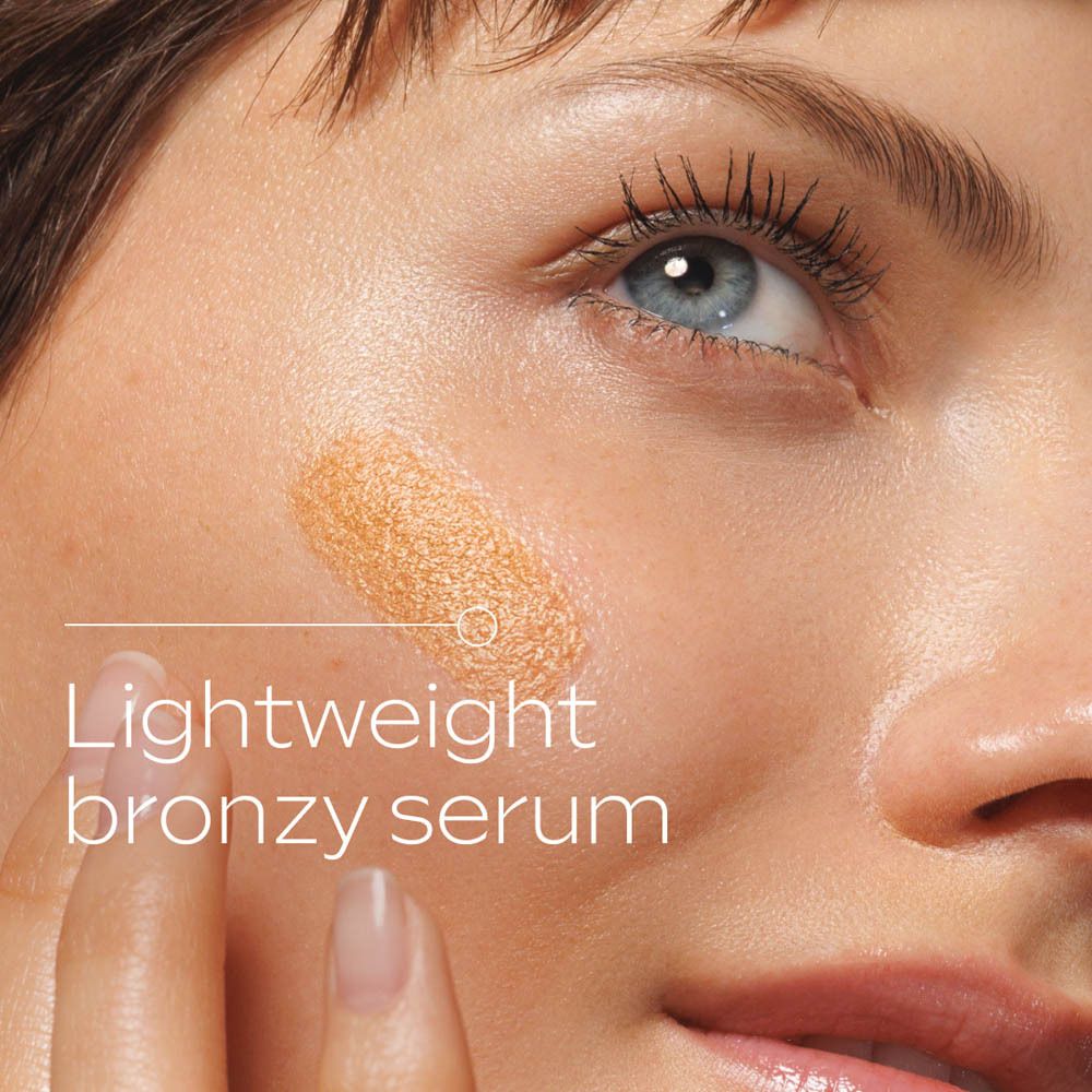 Close-up: vrouw met aangebrachte Weleda Sunkissed Bronzing Serum Drops. Tekst.