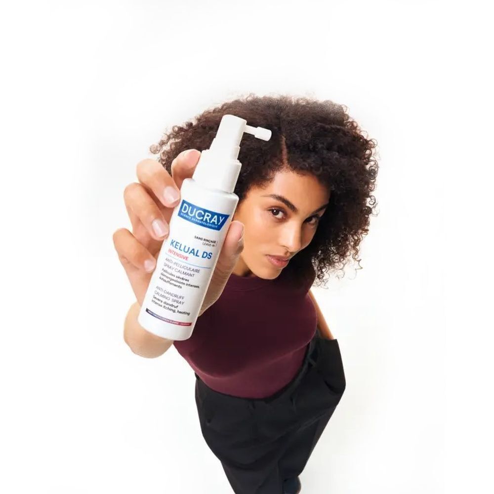Spray Ducray Kelual DS Intensive. Flacon blanc avec vaporisateur. Nom du produit et texte en bleu et blanc.