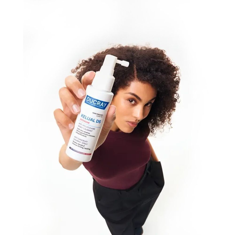 Ducray Kelual DS Intensive spray. Witte fles met sproeikop. Productnaam en tekst in blauw en wit.