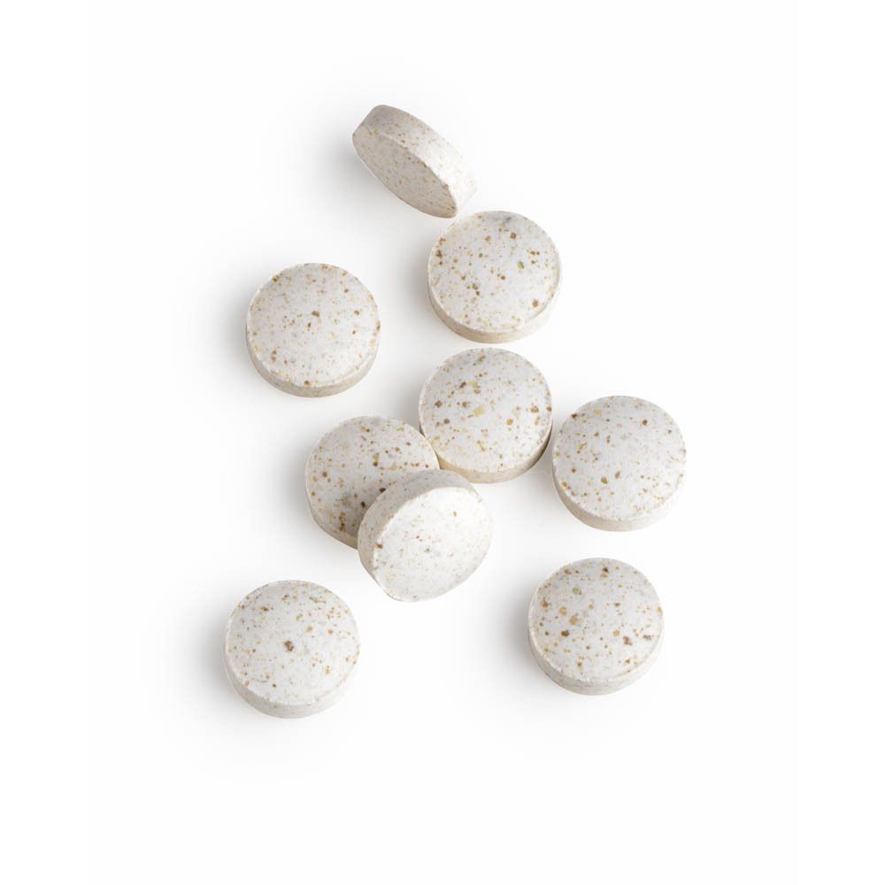 Meerdere tabletten. Ronde, beige tabletten met kleine puntjes. Bovenaanzicht.