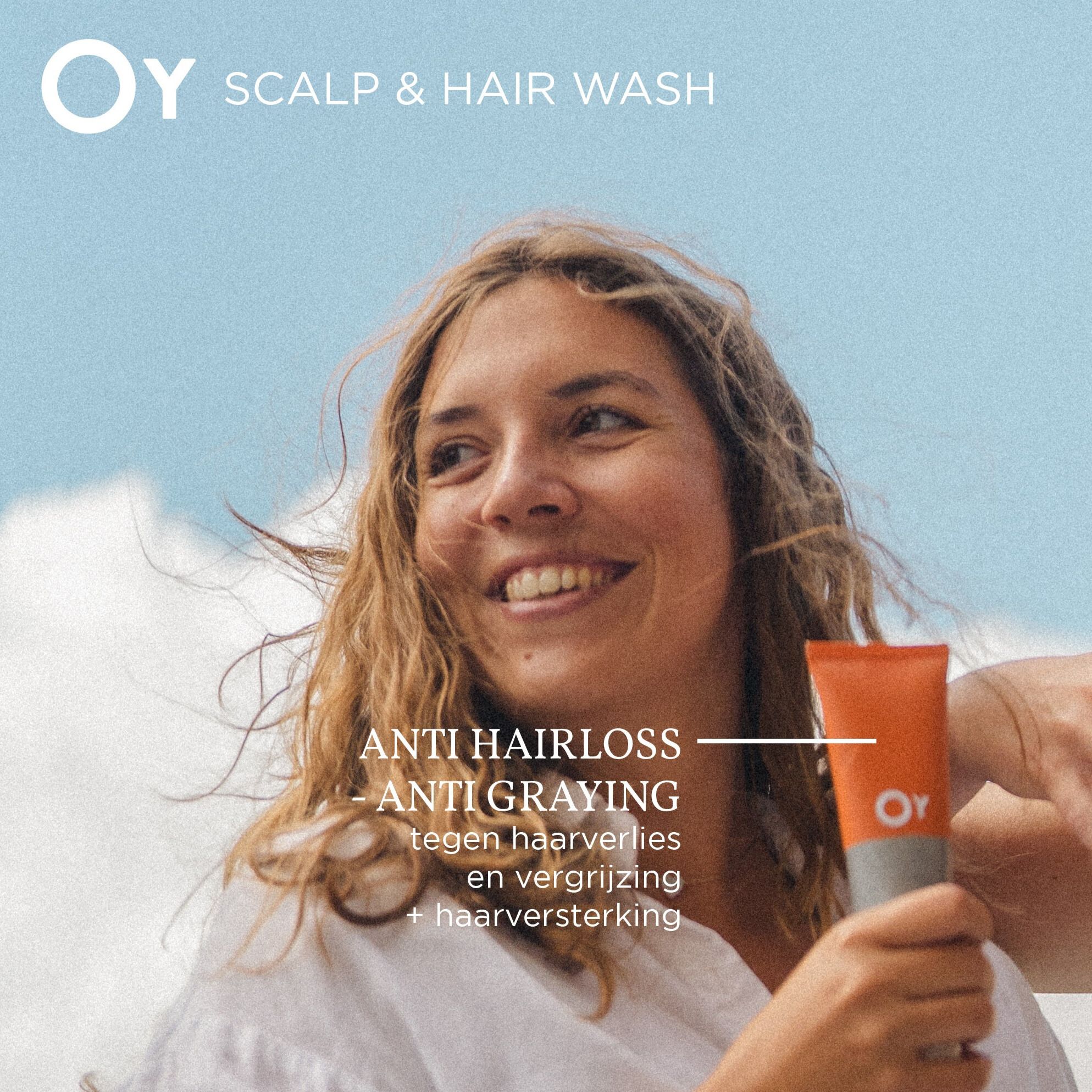 Vrouw houdt een tube vast. OY-logo en productnaam. Tekst over anti-haaruitval en anti-grijzend.