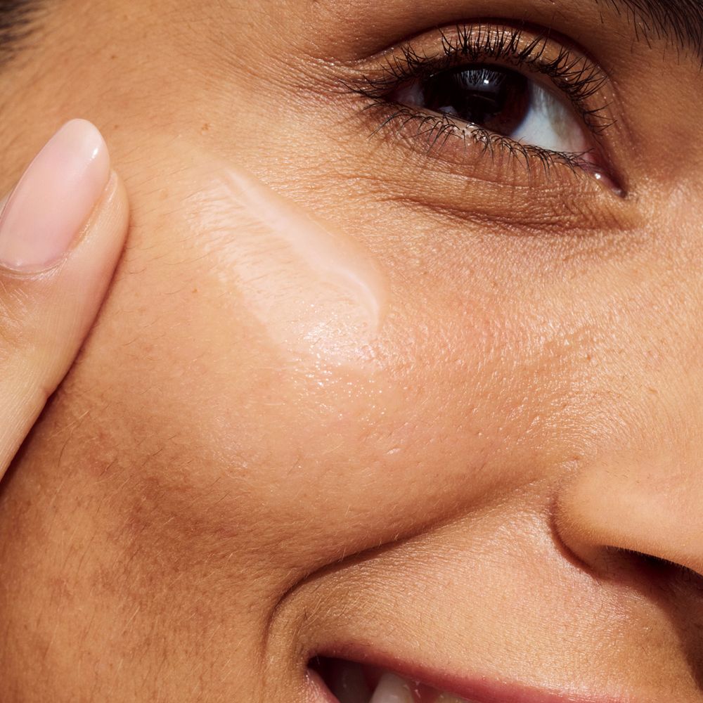 Persoon brengt serum aan op gezicht. Productnaam of merk niet zichtbaar.