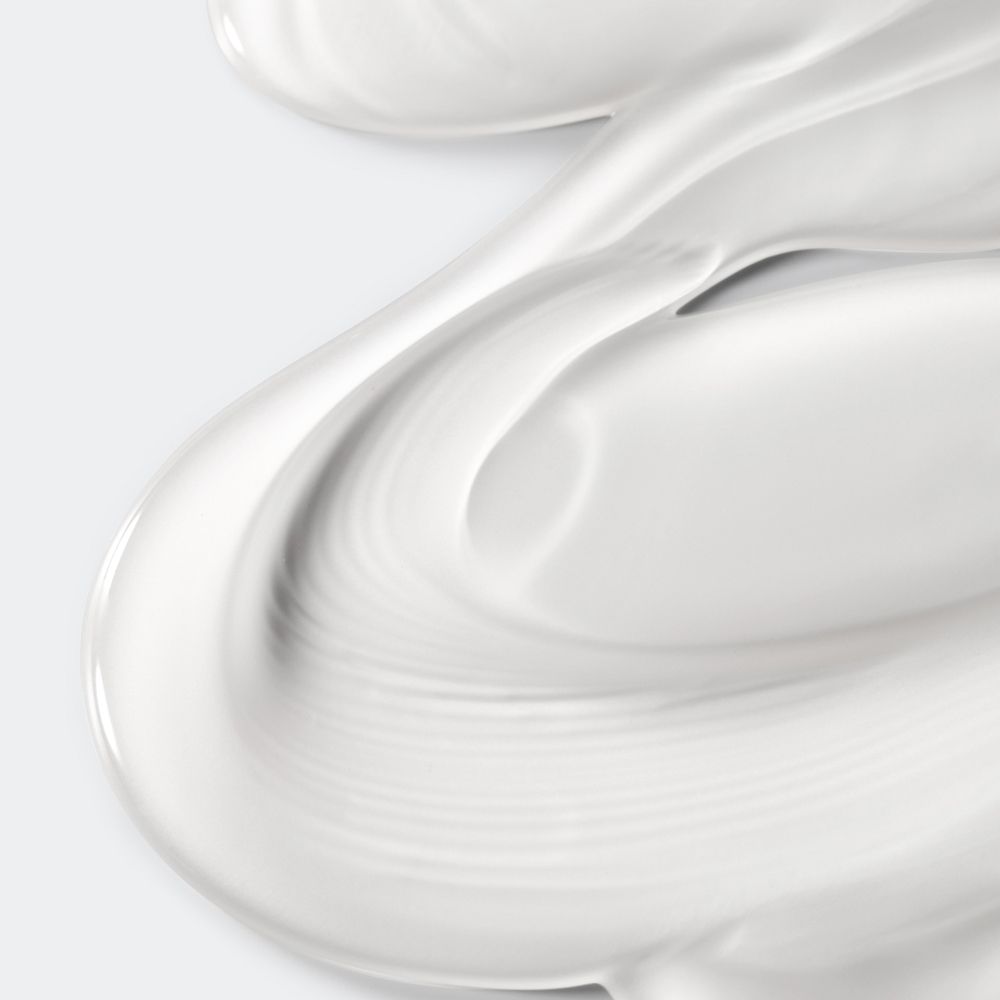 Close-up van witte crème. De crème is gegolfd en heeft een gladde textuur.