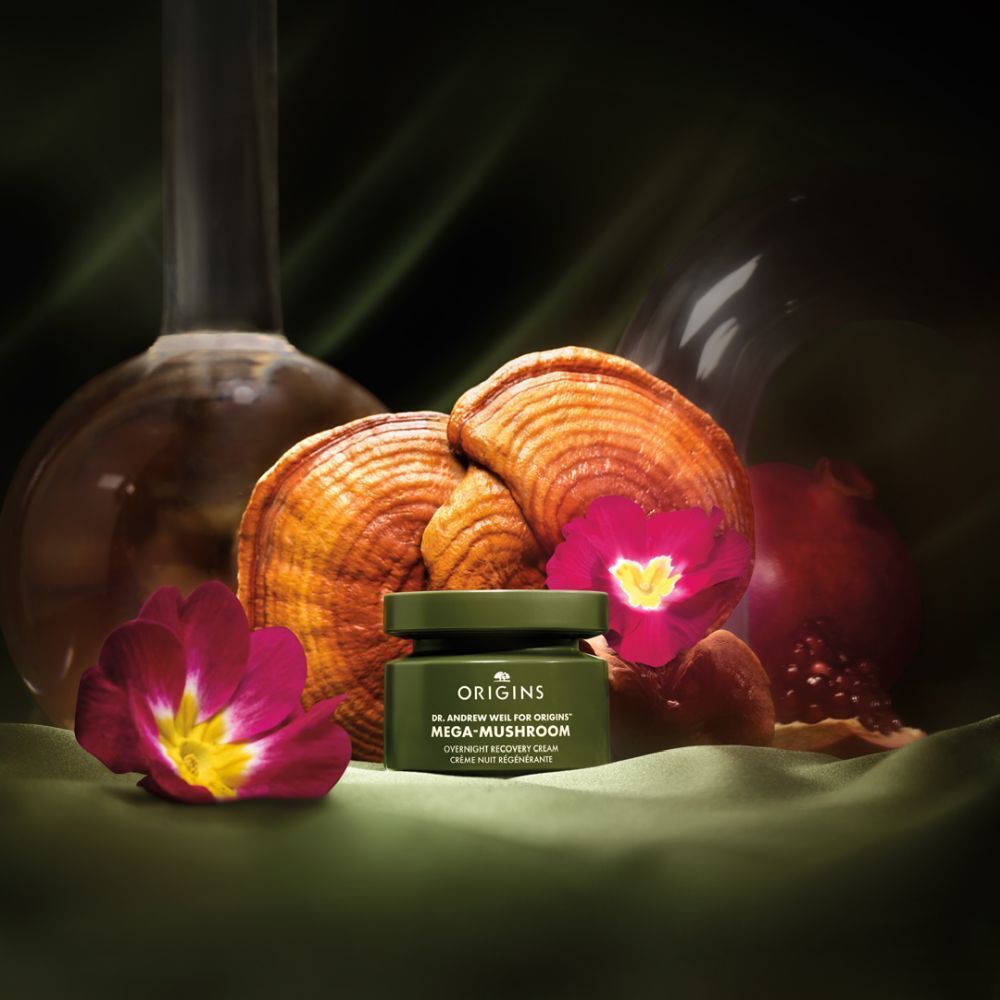 Groene pot met crème, paddenstoelen, bloemen, granaatappel. Tekst Origins, Mega-Mushroom.