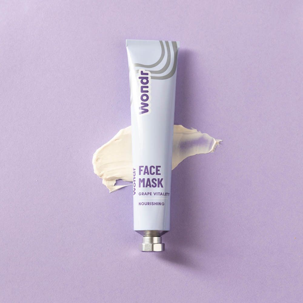 Tube en crème op paarse achtergrond. Opschrift: Wondr, Face Mask, Grape Vitality, Nourishing. Crème-uitstrijk.
