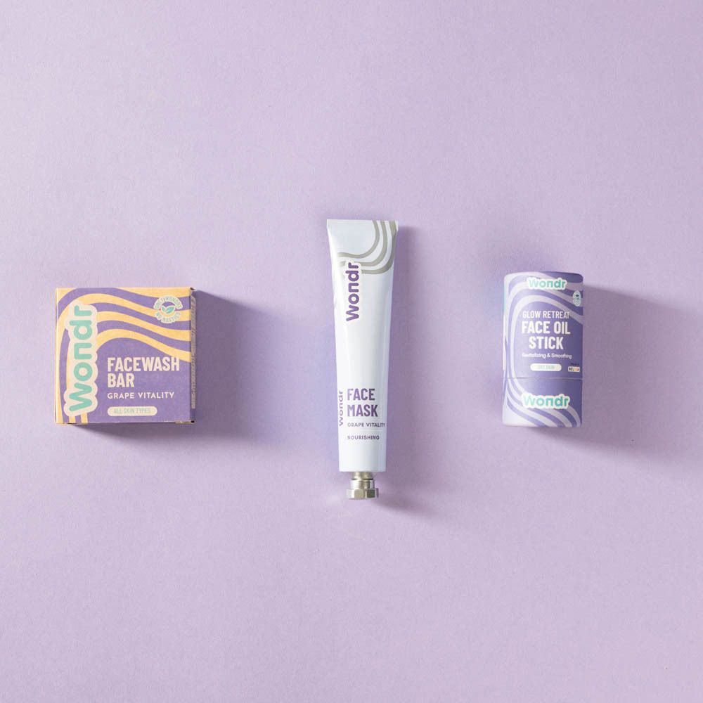 Drie producten op paarse achtergrond. Tube, doos en roll-on. Opschrift: Wondr.