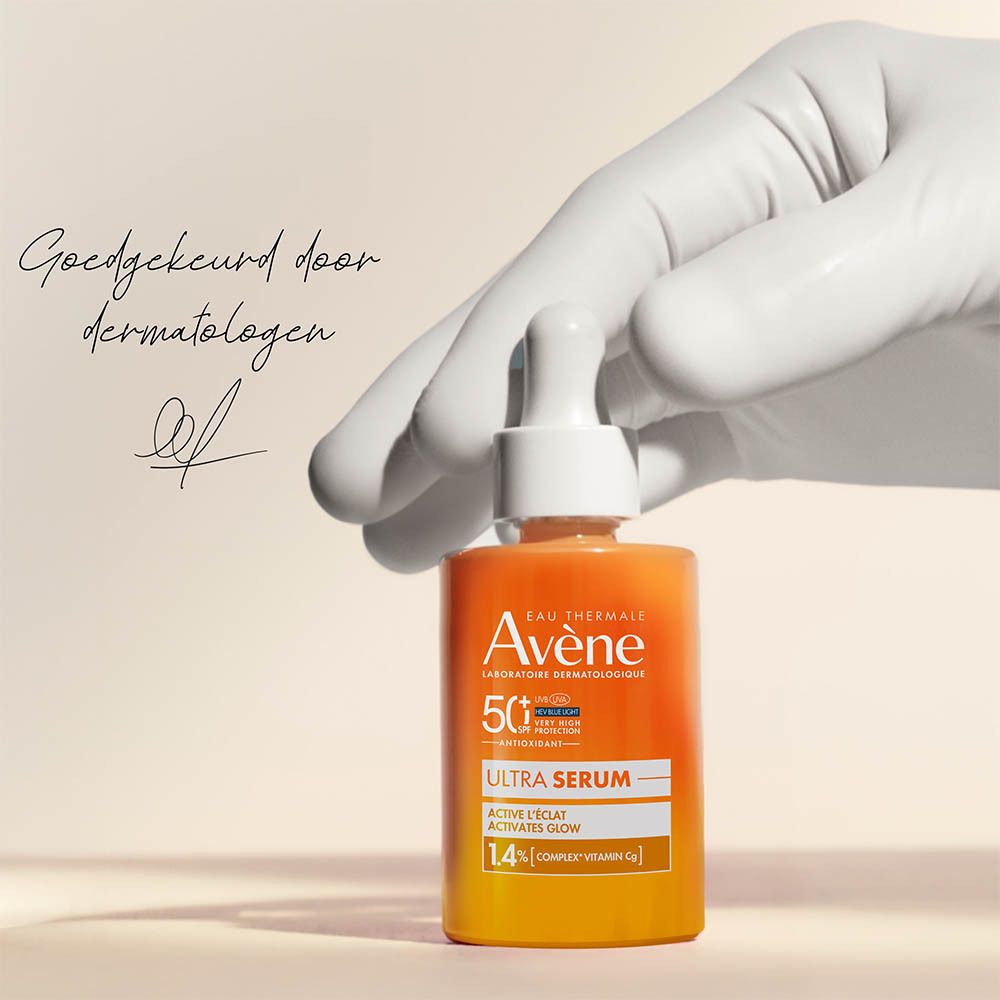 Hand houdt flesje Avène Solaire Ultra Serum SPF50+ vast. Handtekening.