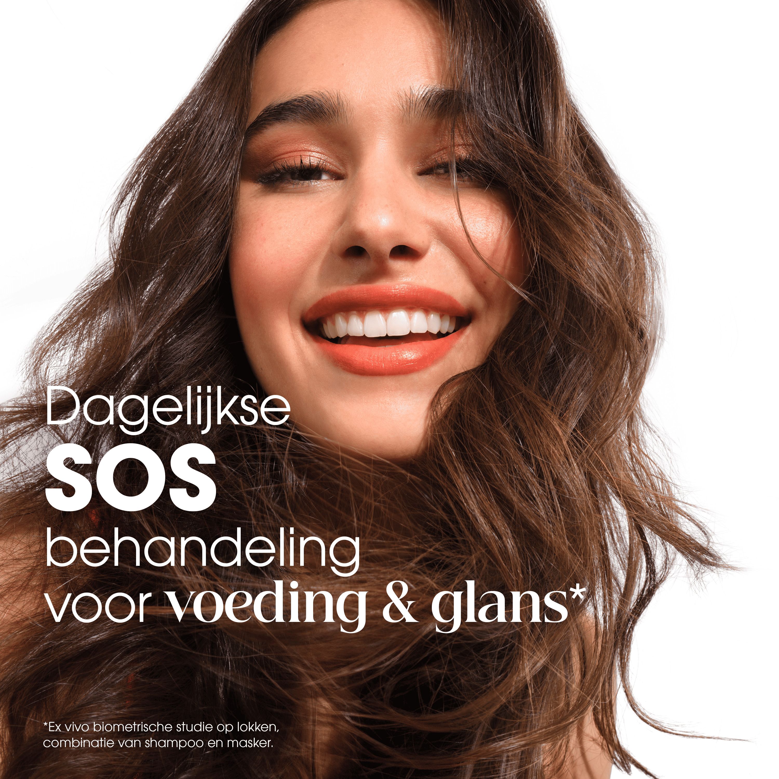 Vrouw met vol, glanzend haar die de Klorane leave-in crème gebruikt.