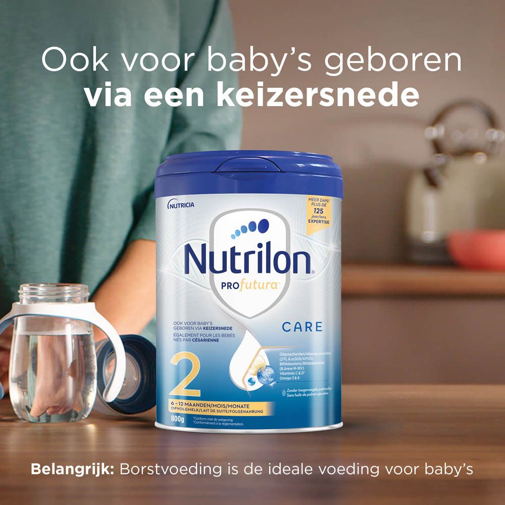 Nutrilon Profutura CARE 2 melkpoeder verpakking op tafel. Flesje zichtbaar. Opschrift: 2, 6-12 maanden, 800g. Tekst: Voor keizersnede.