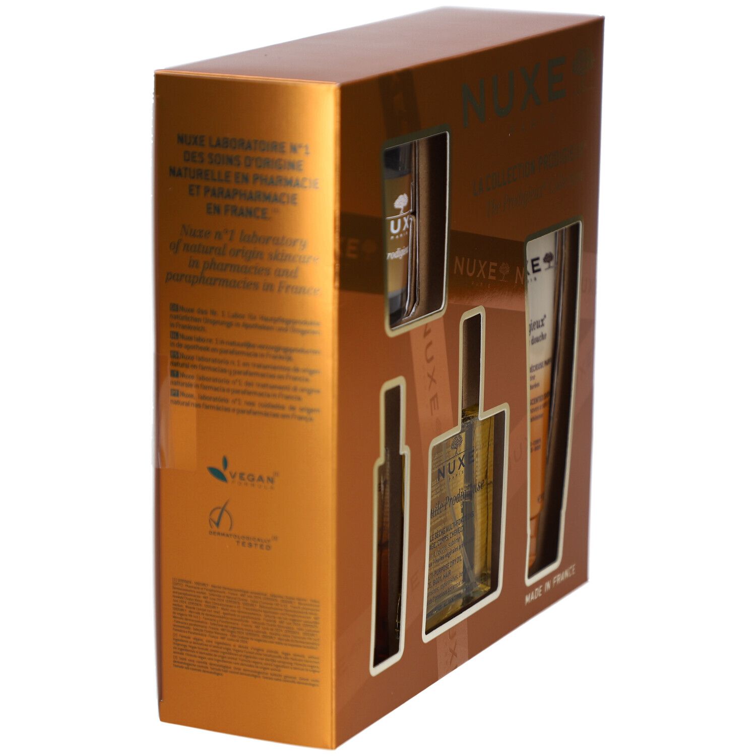 Coffret cadeau doré, vue de côté. Texte au dos et logo Vegan. Marque Nuxe. Fabriqué en France.