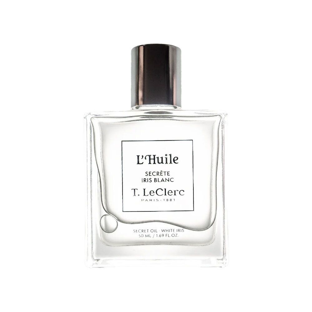 Vierkante glazen fles met zilveren dop. Etiket met tekst: L'Huile Secrète Iris Blanc, T. LeClerc. Duidelijke inhoud zichtbaar.