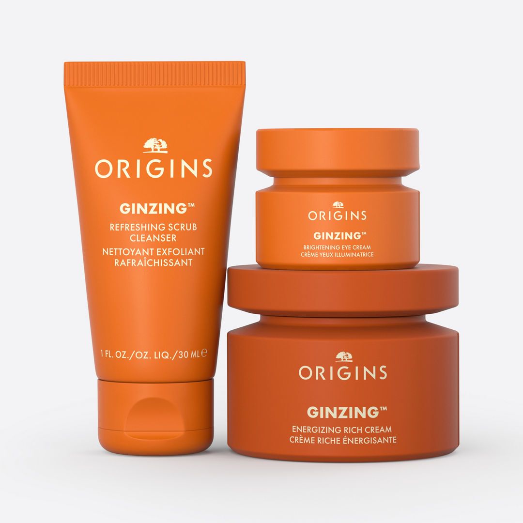 Drie oranje potten en een tube. De producten dragen de naam Origins en Ginzing.