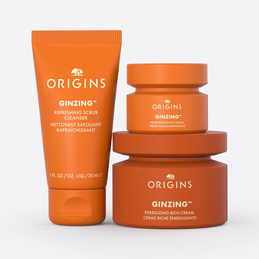 Trois pots oranges et un tube. Les produits portent le nom Origins et Ginzing.