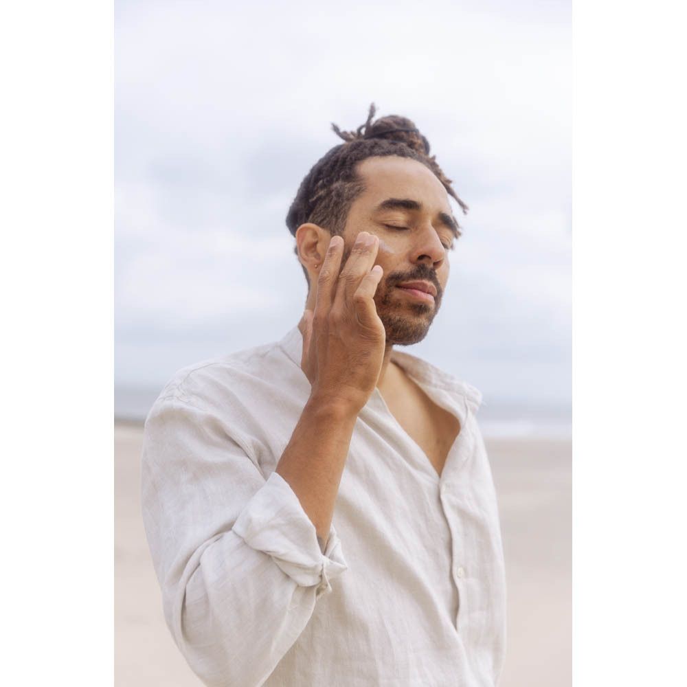 Man met bloem voor zijn gezicht. Geen producten zichtbaar.